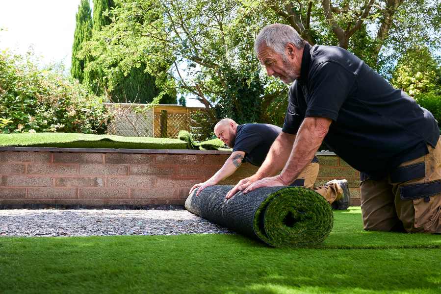 2 men rolling up turf